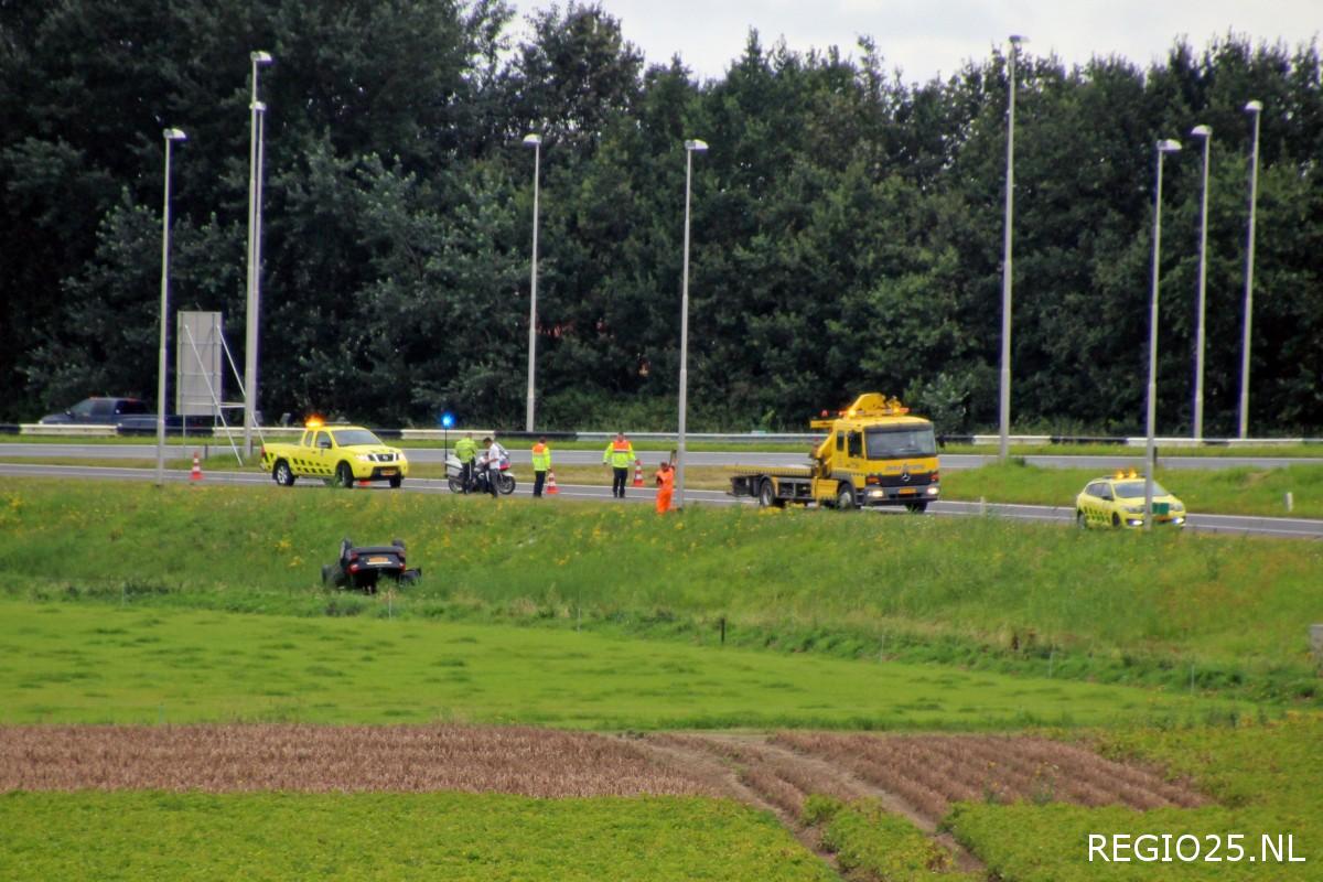 Auto over de kop langs A6/N50