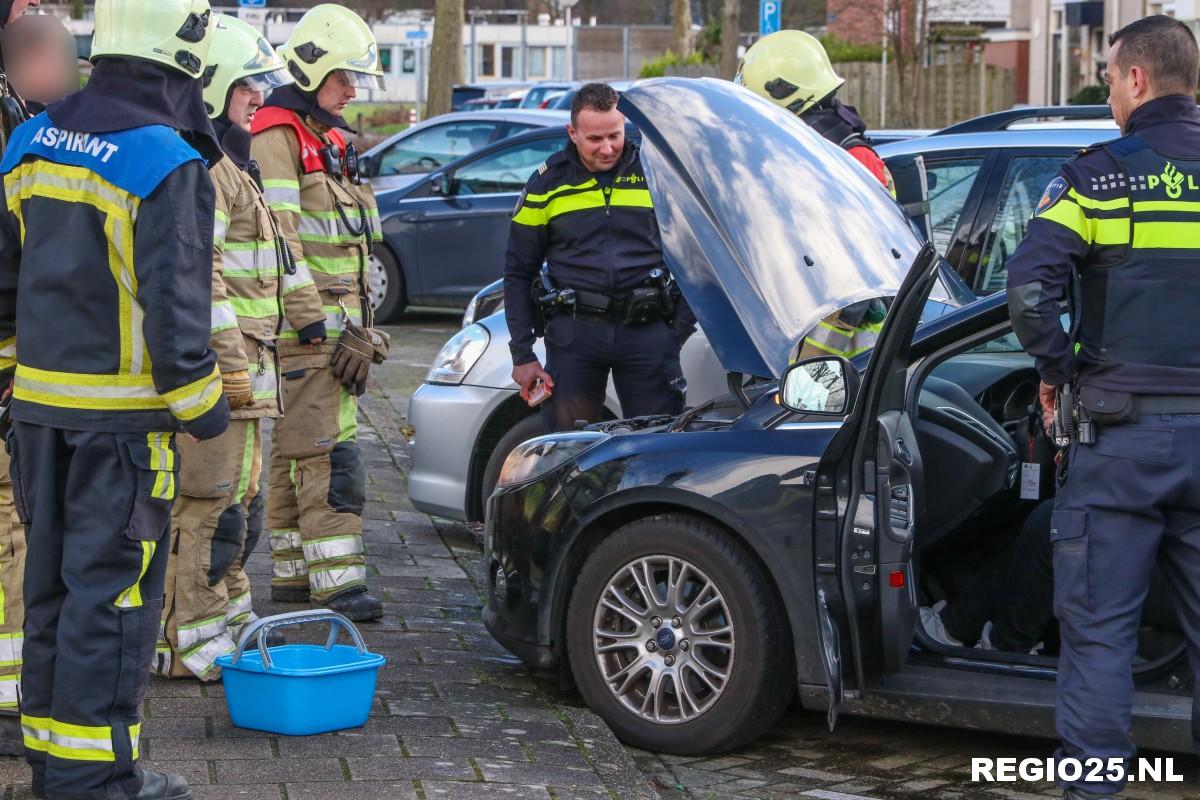 Kleine brand onder motorkap van auto