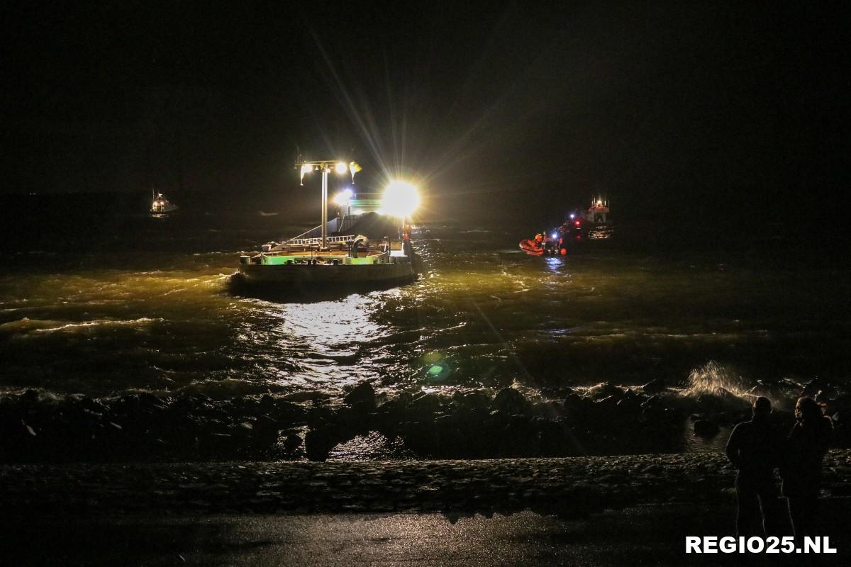 Vrachtschip vol met water tegen de dijk