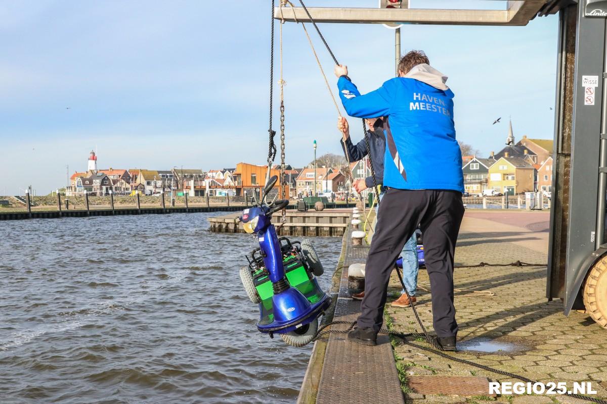 Oudere man met scootmobiel te water