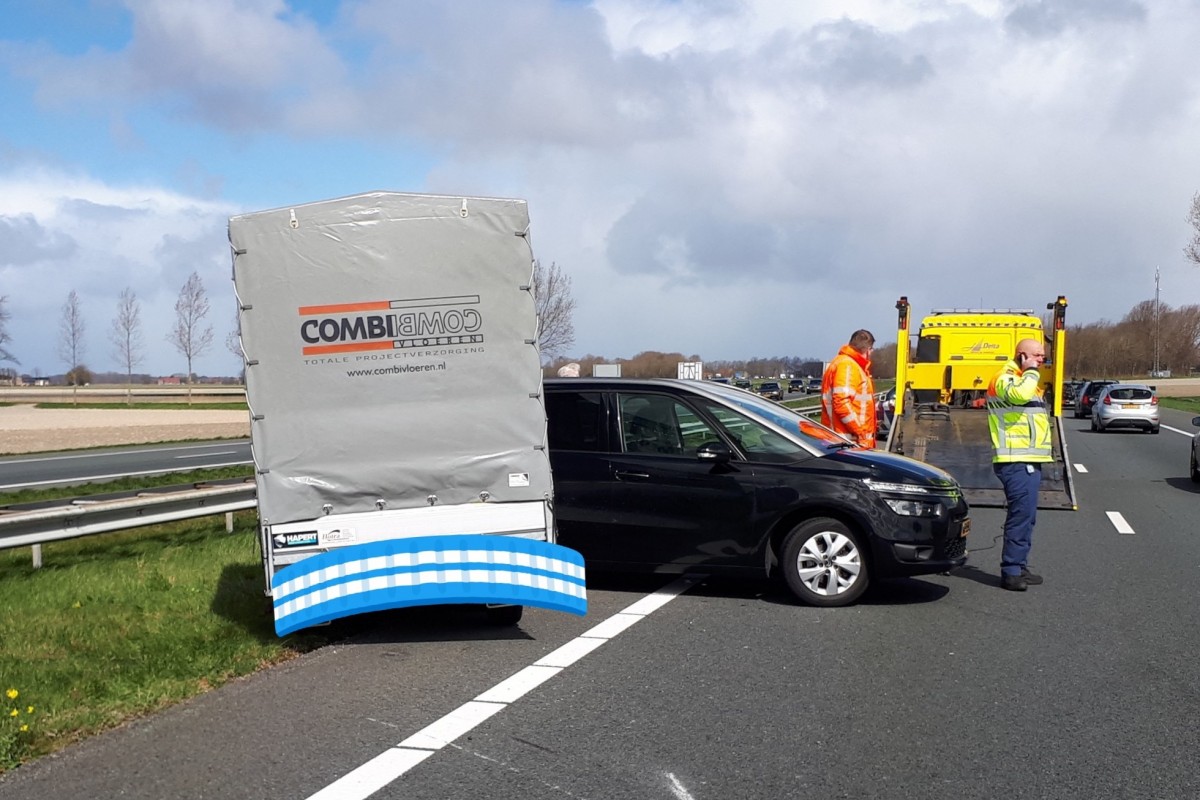 Auto met aanhanger geschaard door harde wind