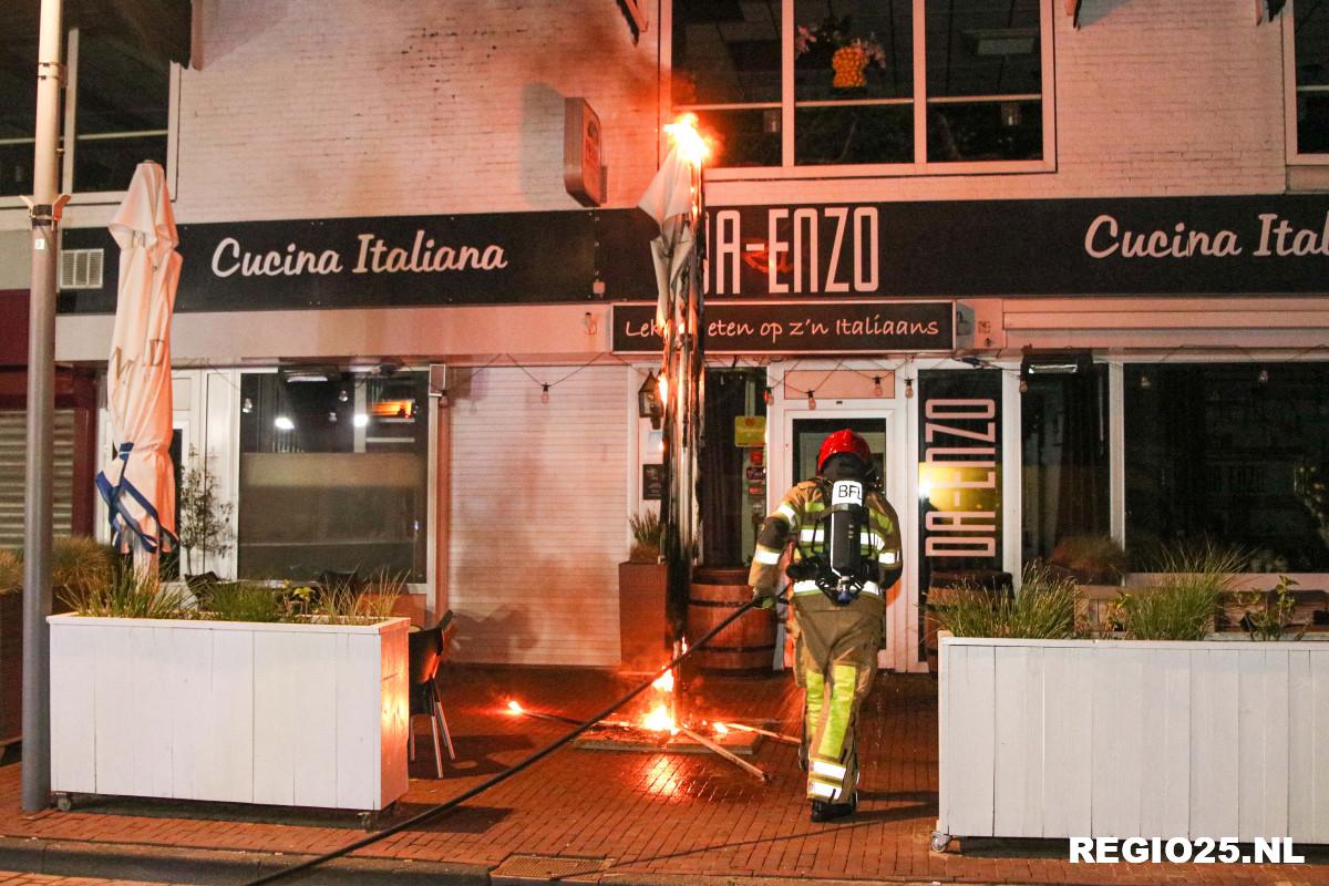 Parasol in brand bij restaurant