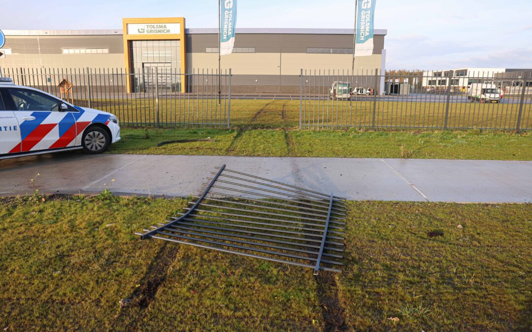 Auto ramt hek en botst tegen bedrijfspand
