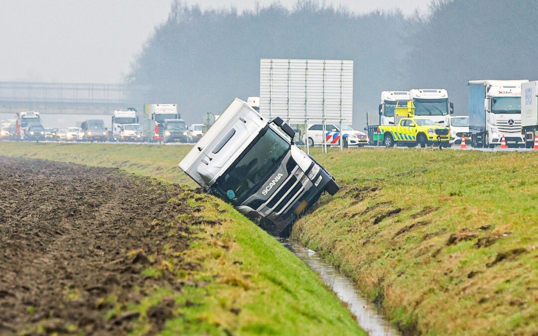 Vrachtwagen belandt in sloot naast A6
