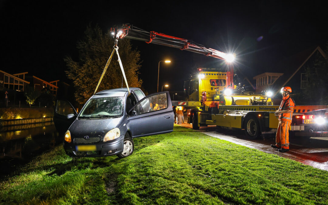Twee jonge mannen met auto te water langs de Nagel